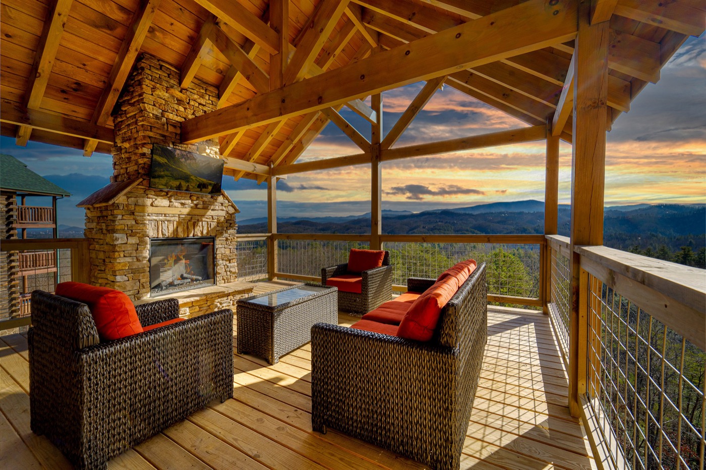 Top-level covered deck with stone fireplace and mountain views