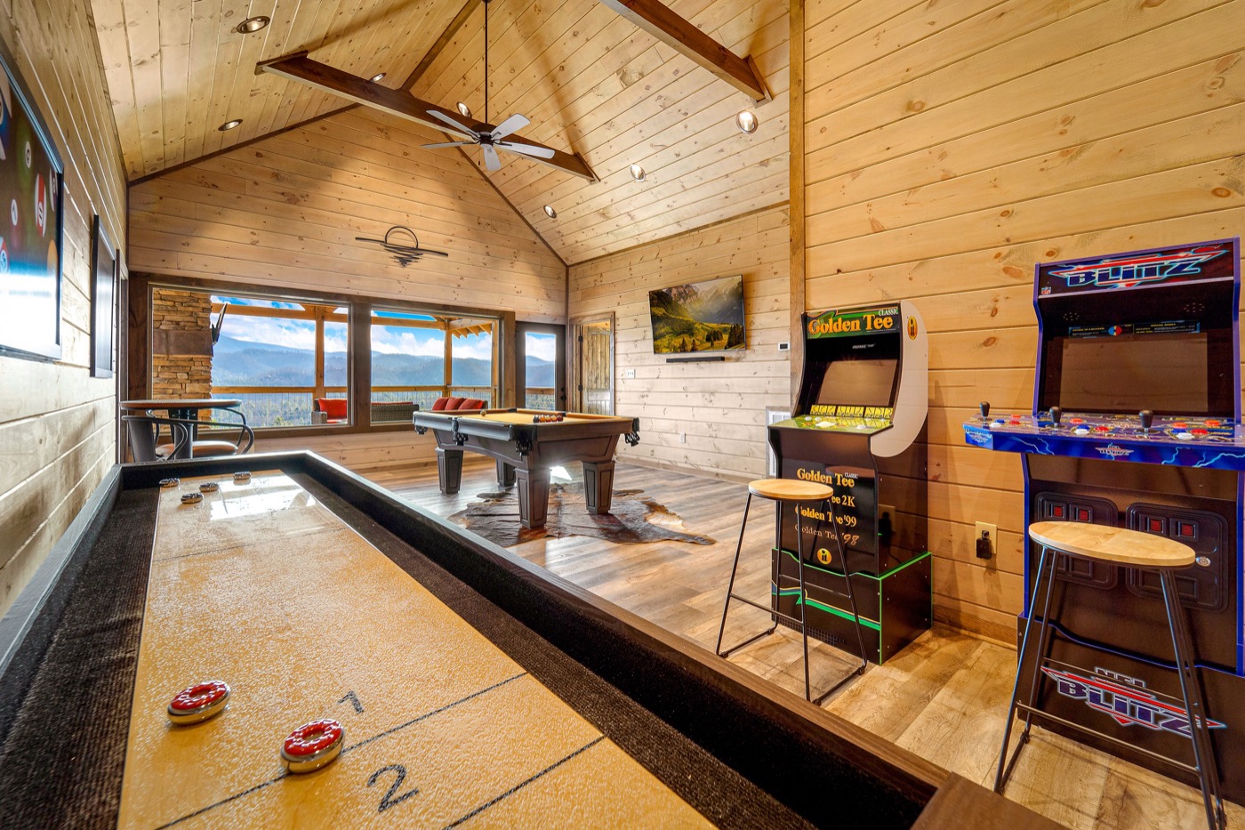 Game room with shuffleboard, pool table and mountain views through windows