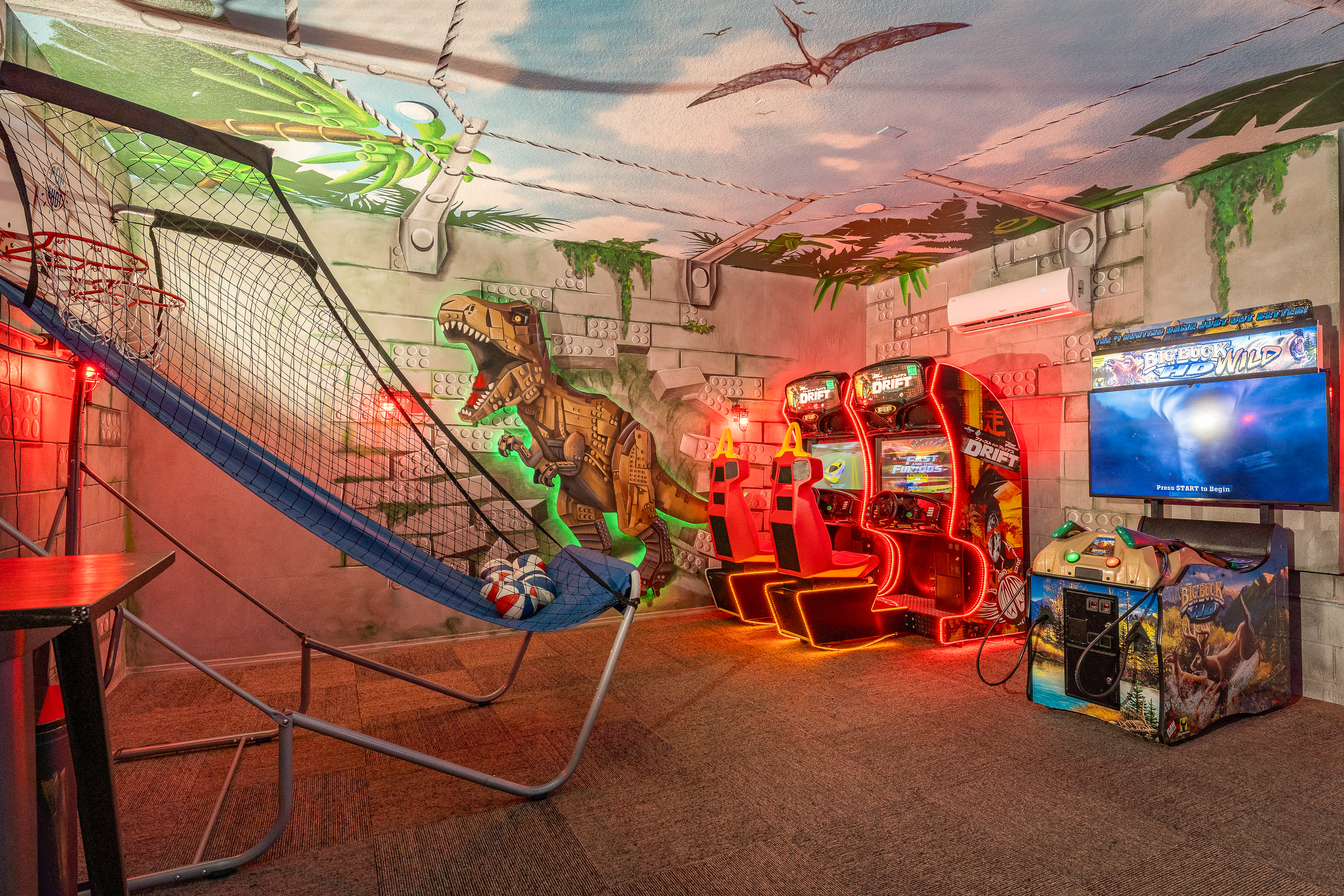 Jurassic Park arcade room with T-Rex mural, Fast+Furious racing games and basketball hoop