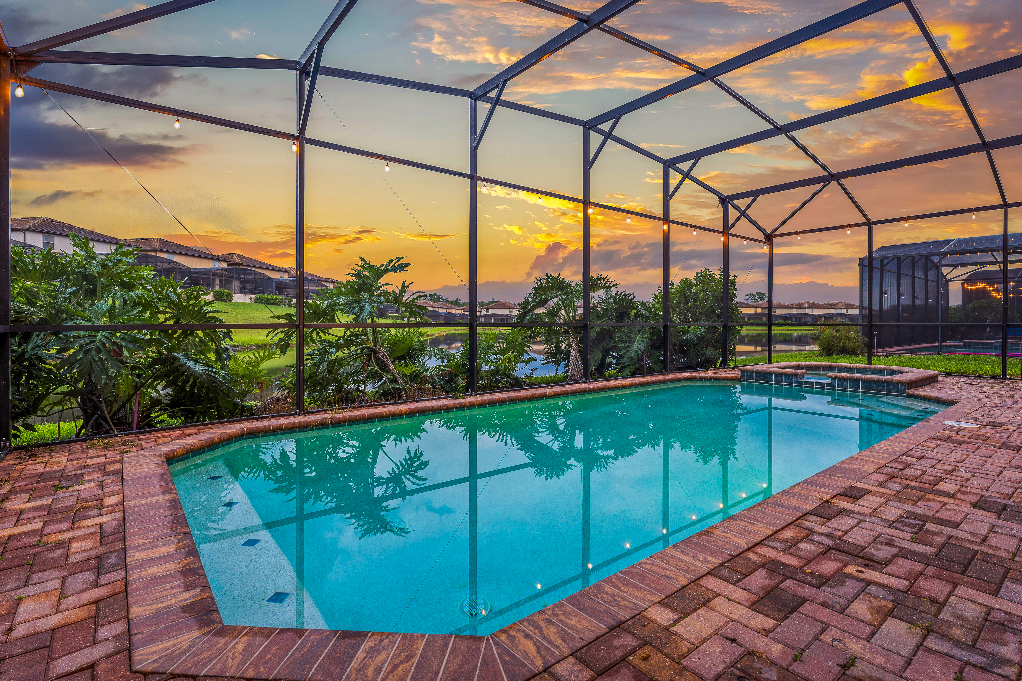 Private pool at sunset with screened enclosure and lake views
